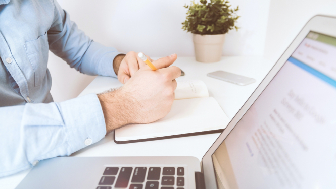 Cilvēks raksta piezīmes bloknotā