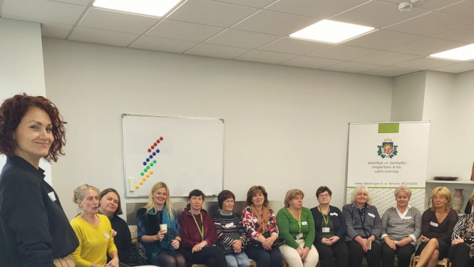 zāle, darbinieki sēž, klausās, lektore stāv, stāsta, projektors